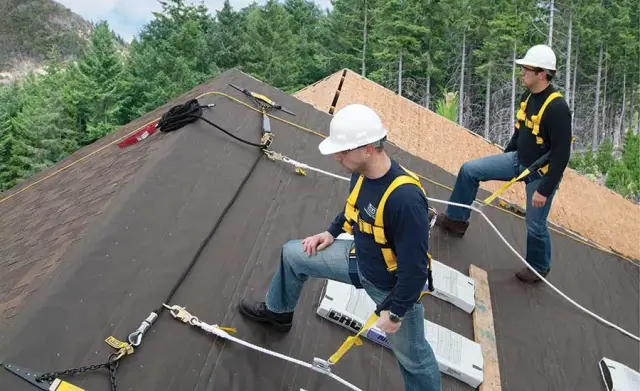 Rocket City Roofing Pros crew working tied off with fall protection harnesses on a steep roof